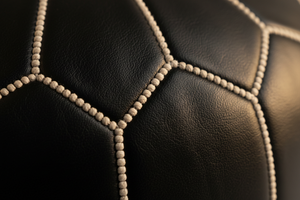Close-up stitching detail of black Moroccan leather pouf
